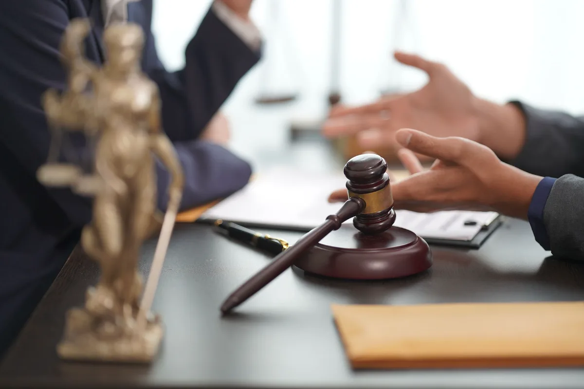 Attorney meeting a client across the desk, gavel in the foreground